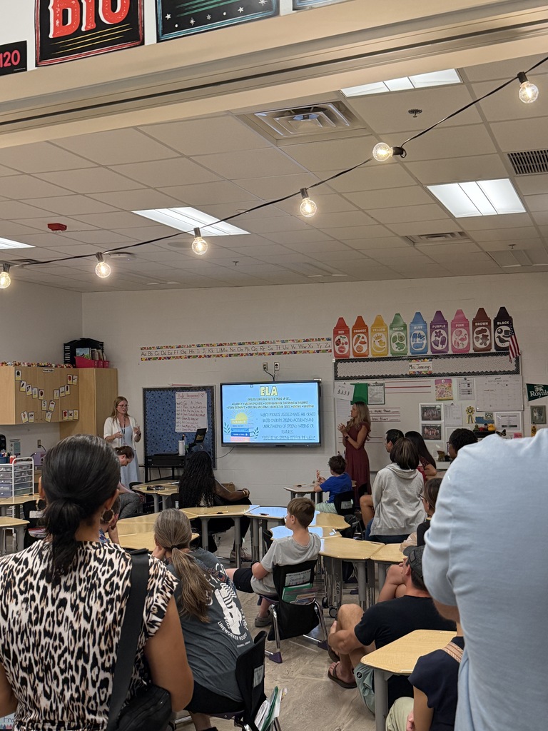 Mrs. Jennings and Mrs. Warber standing at the front of their classroom presenting to their parents during Open house.