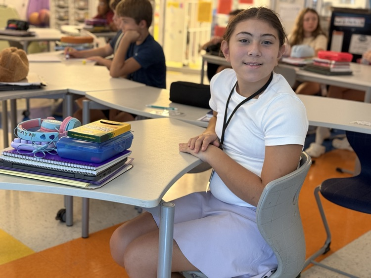 a student smiling at her desk
