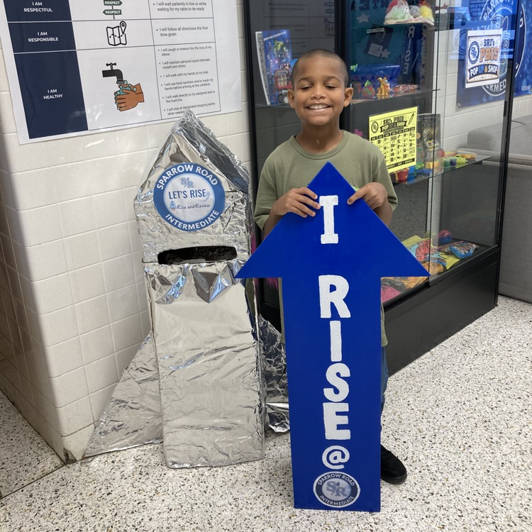 A student with the I RISE arrow in the main lobby.