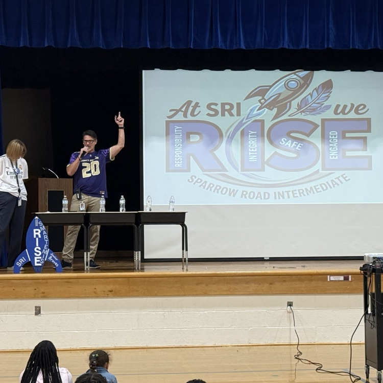 Admin on stage with SMARTemis and a At SRI we RISE on the large projection screen.