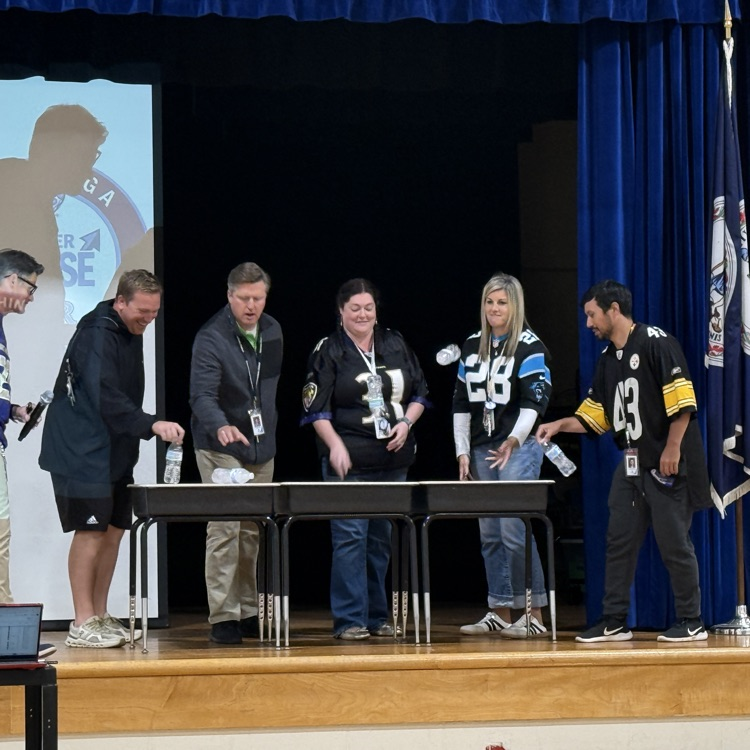 5th grade teachers flipping water bottles on stage.
