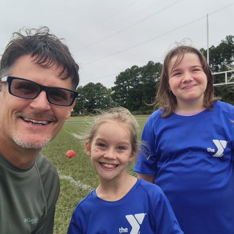 Mr. Triolet smiling with students. 