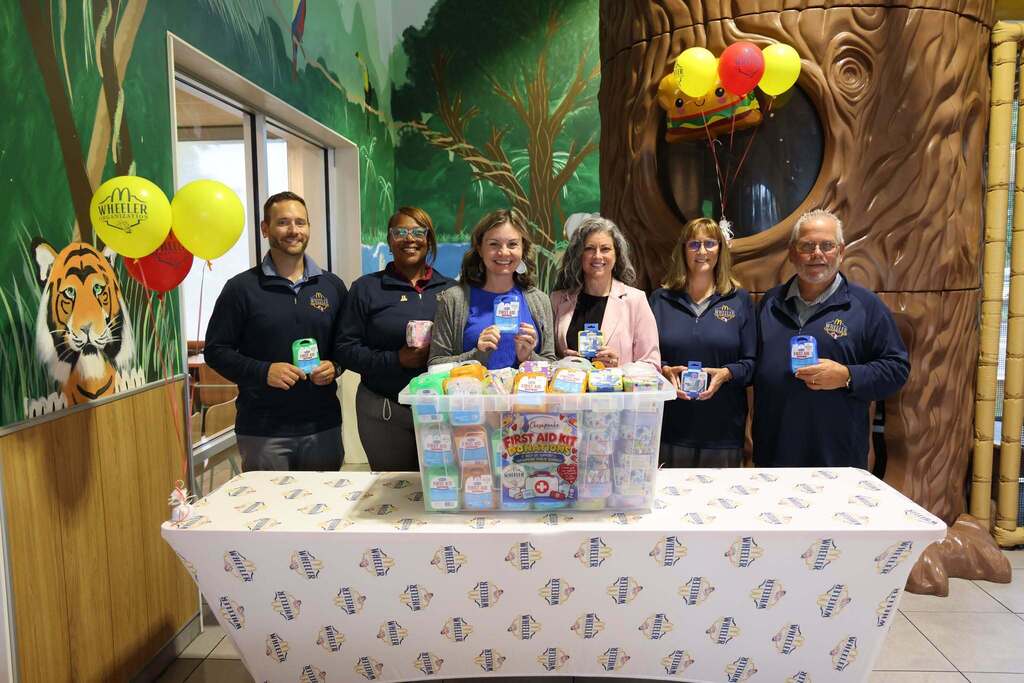 Group of people standing inside McDonald's accepting donations of first aid kits.