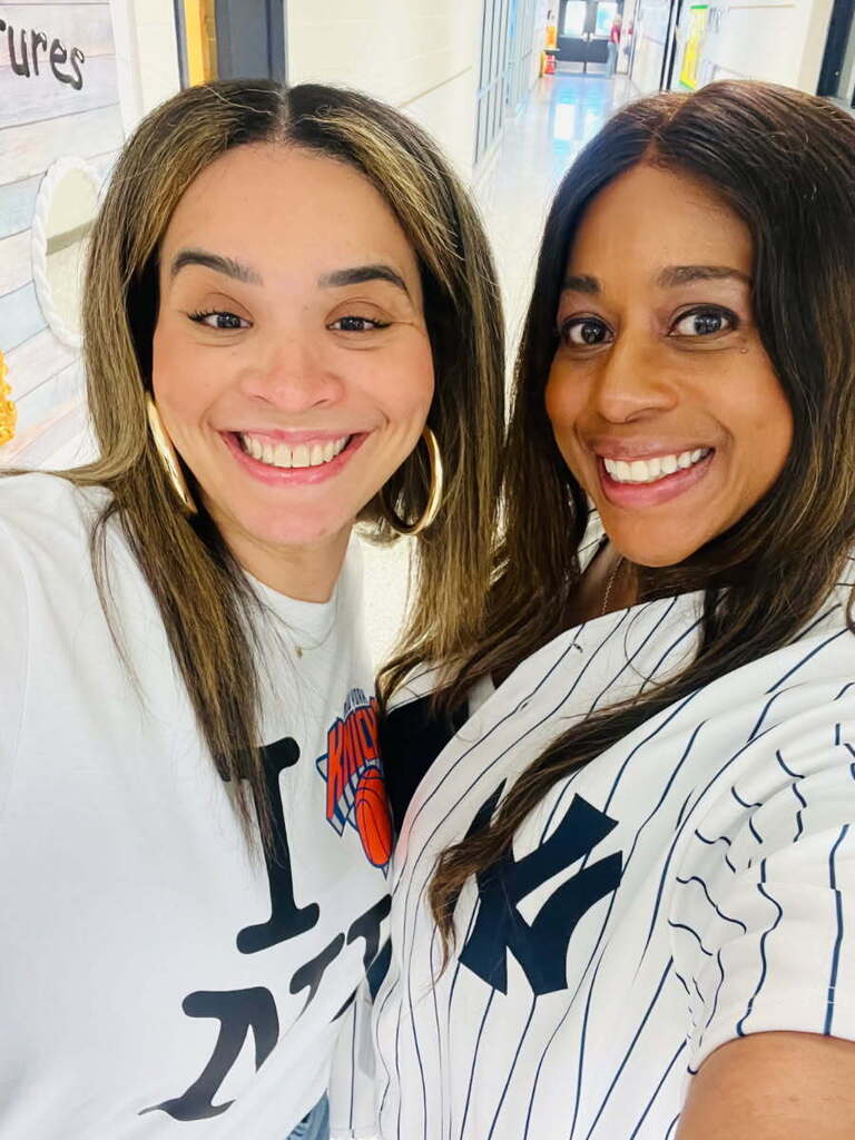 teacher and principal pose in their Knicks and Yankees jerseys