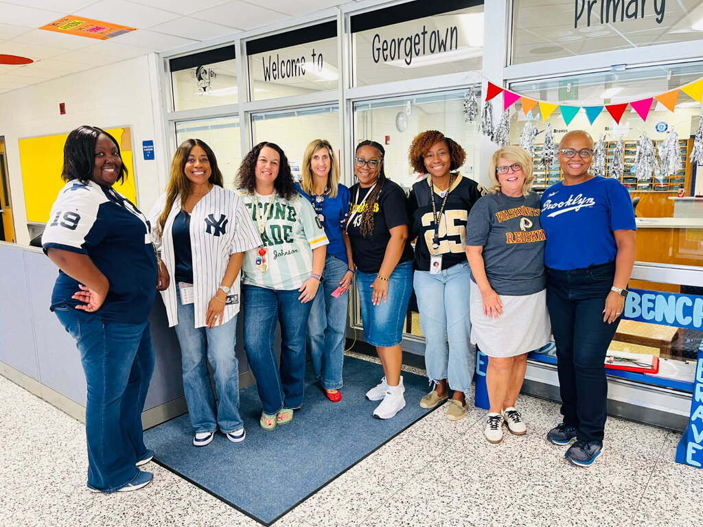 staff pose in their jerseys to show school spirit for jersey day