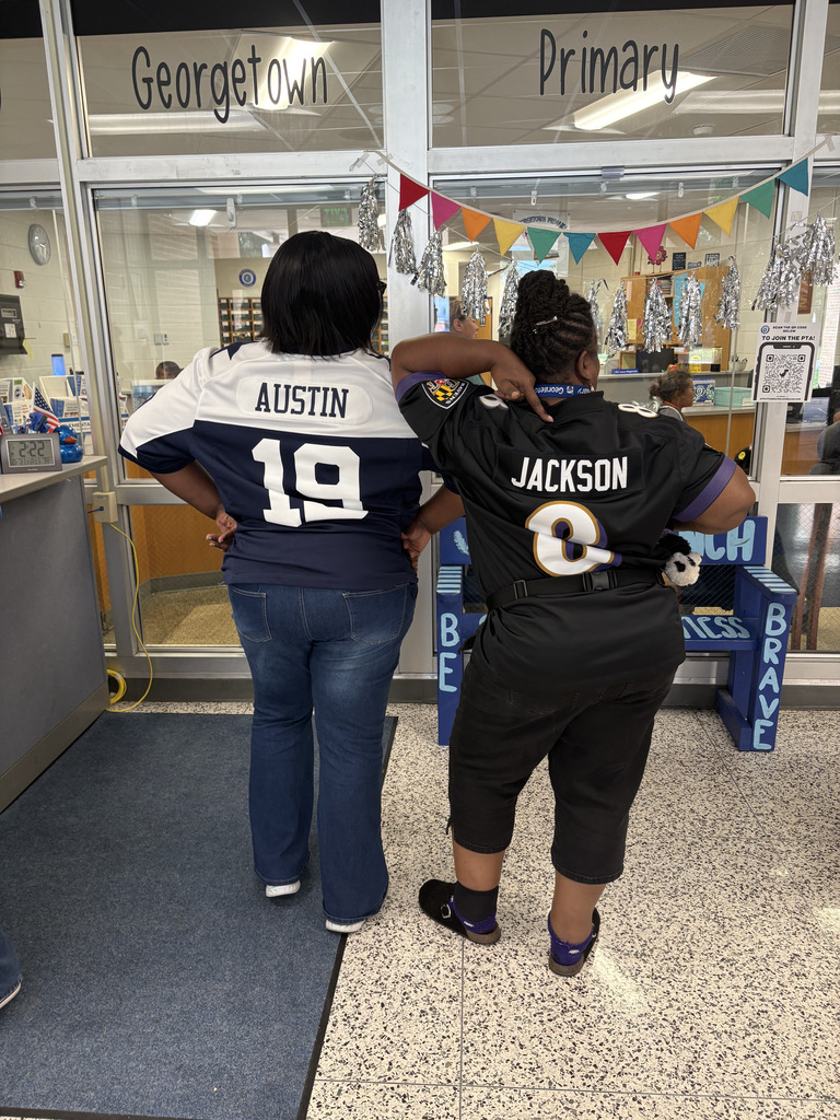 staff pose with their Dallas Cowbow and Baltimore Raven jersey