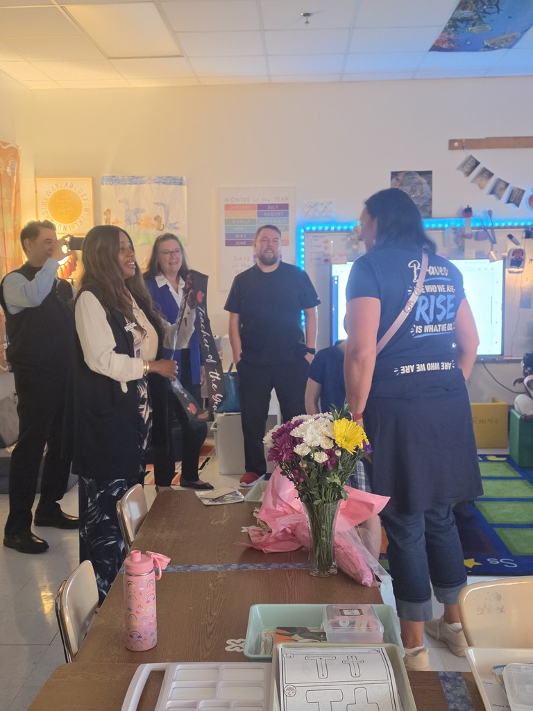 Mrs. Alexander presenting the teacher of the year sash to Mrs. Yohe