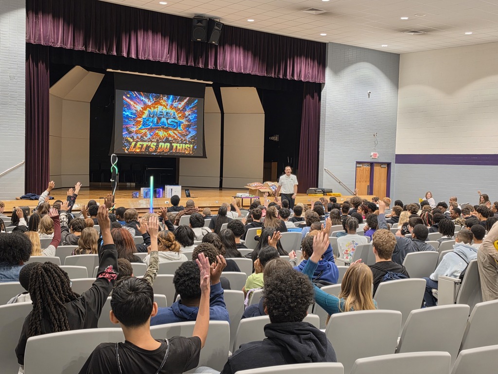 Students raising their hands at the mega Blast fundraiser