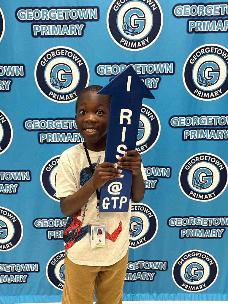 student posing with I RISE arrow after receiving positive office referral