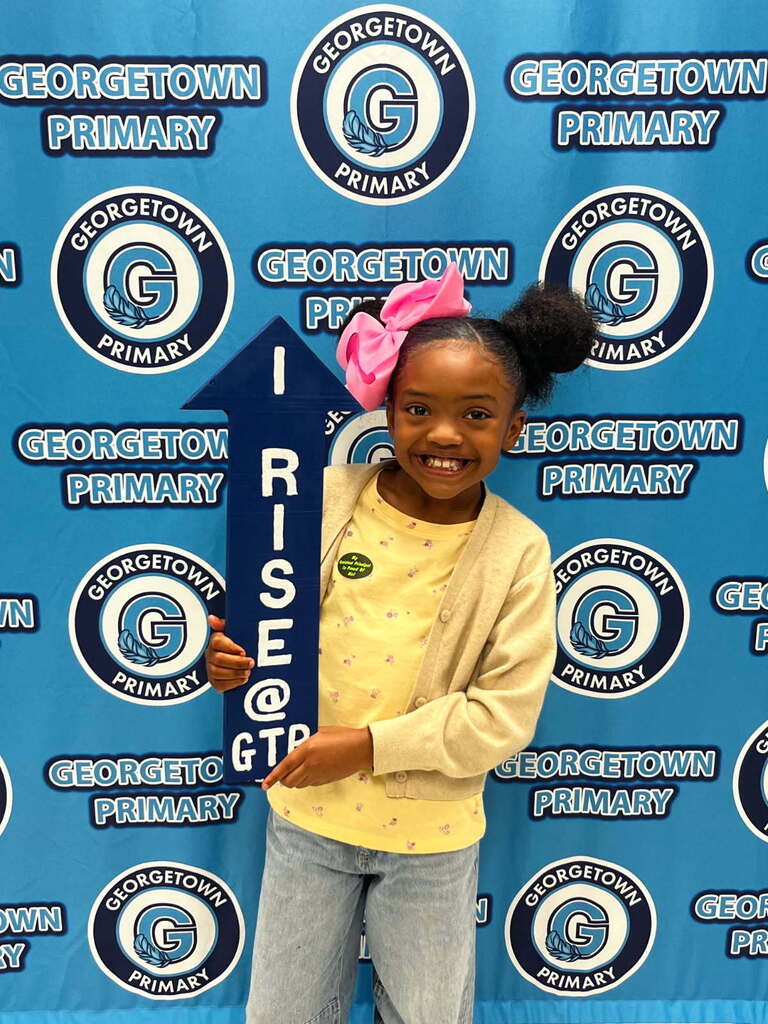 student posing with I RISE arrow after receiving positive office referral