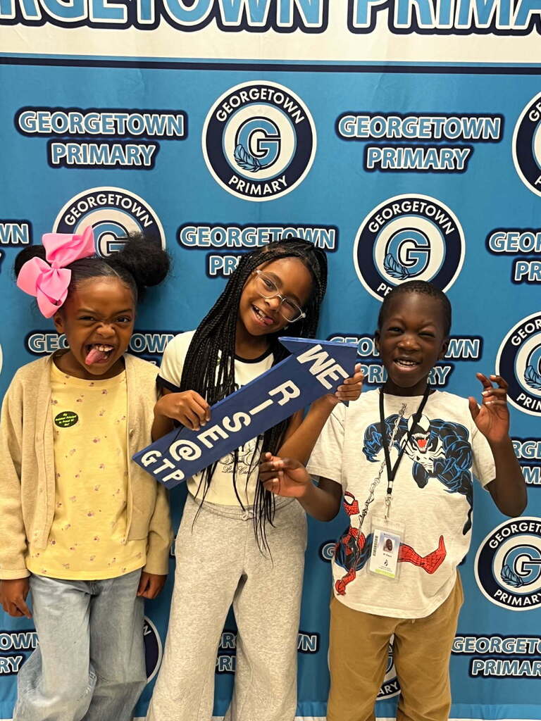 students posing with I RISE arrow after receiving positive office referral