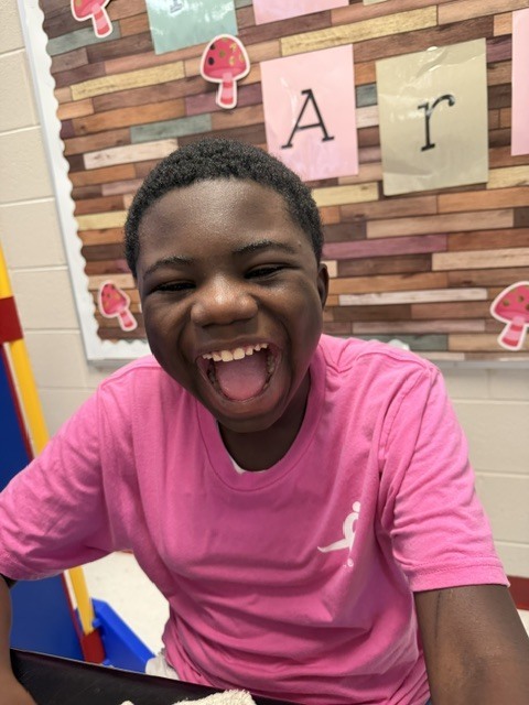 Students smiling, wearing pink for the Pink Out spirit day