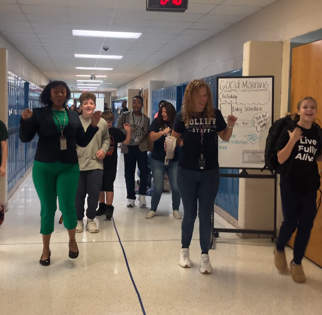 Staff and students dancing to the Cupid Shuffle in the hallway before classes