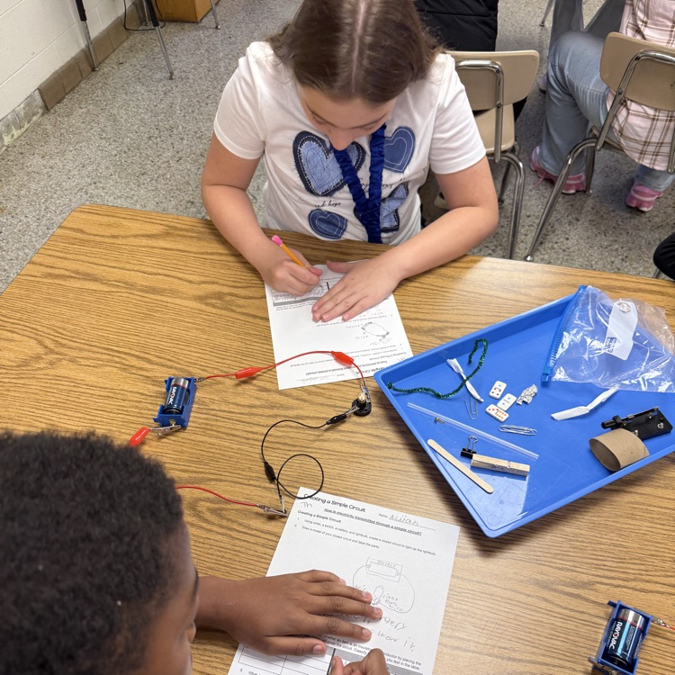 students working on lab sheet with a simple circuit created.