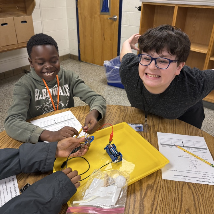 students smiling and laughing while creating their circuit.