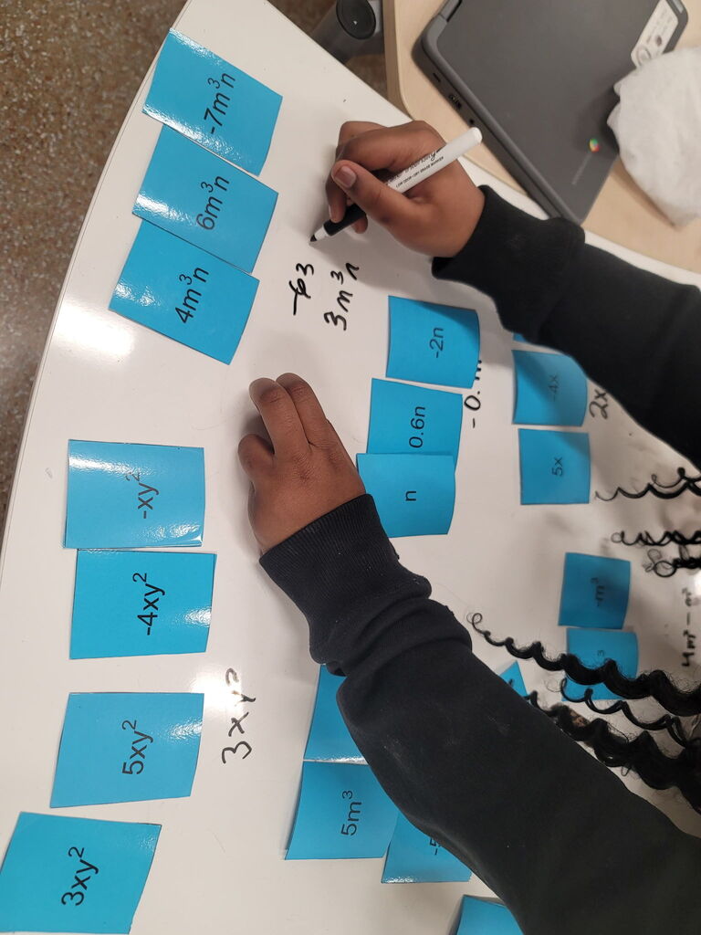 8th grade math students using dry erase tables to work on math problems