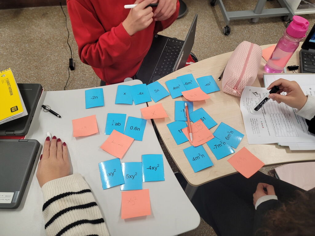 8th grade math students using dry erase tables to work on math problems