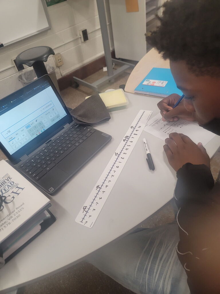 8th grade math student using dry erase tables to work on math problems