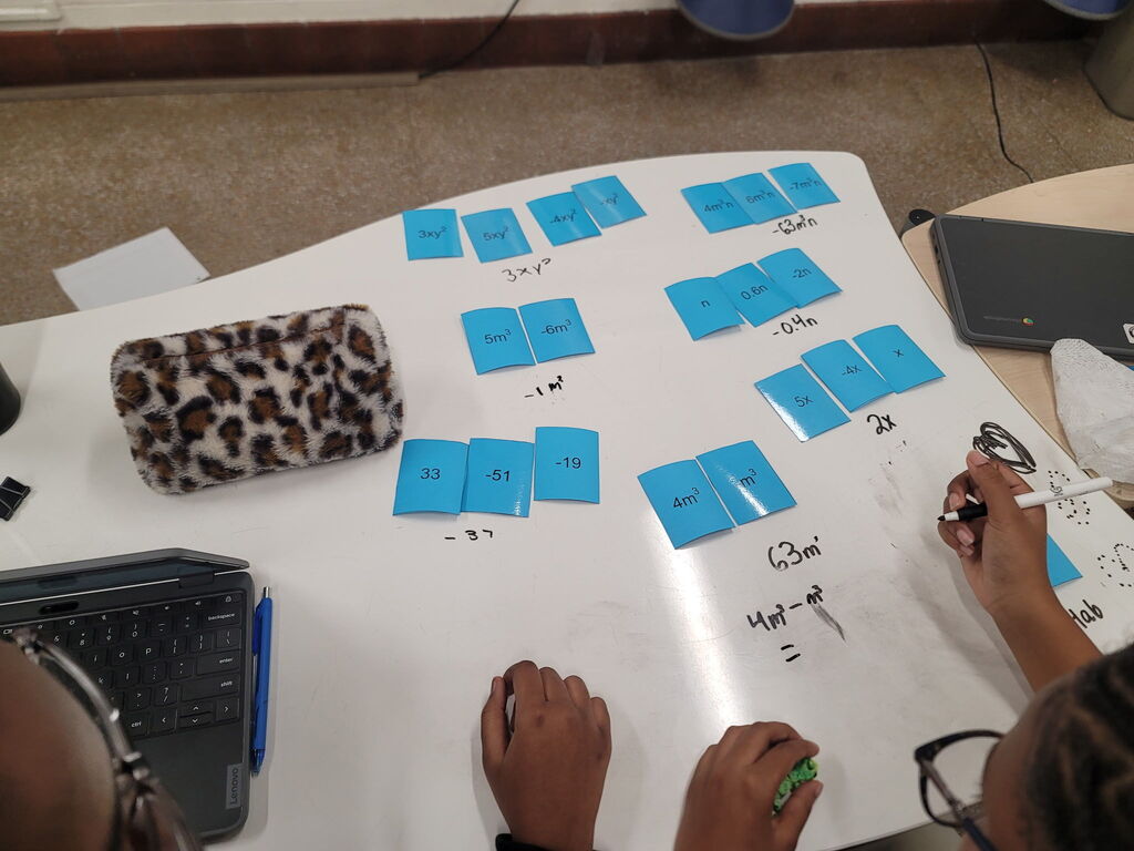 8th grade math students using dry erase tables to work on math problems