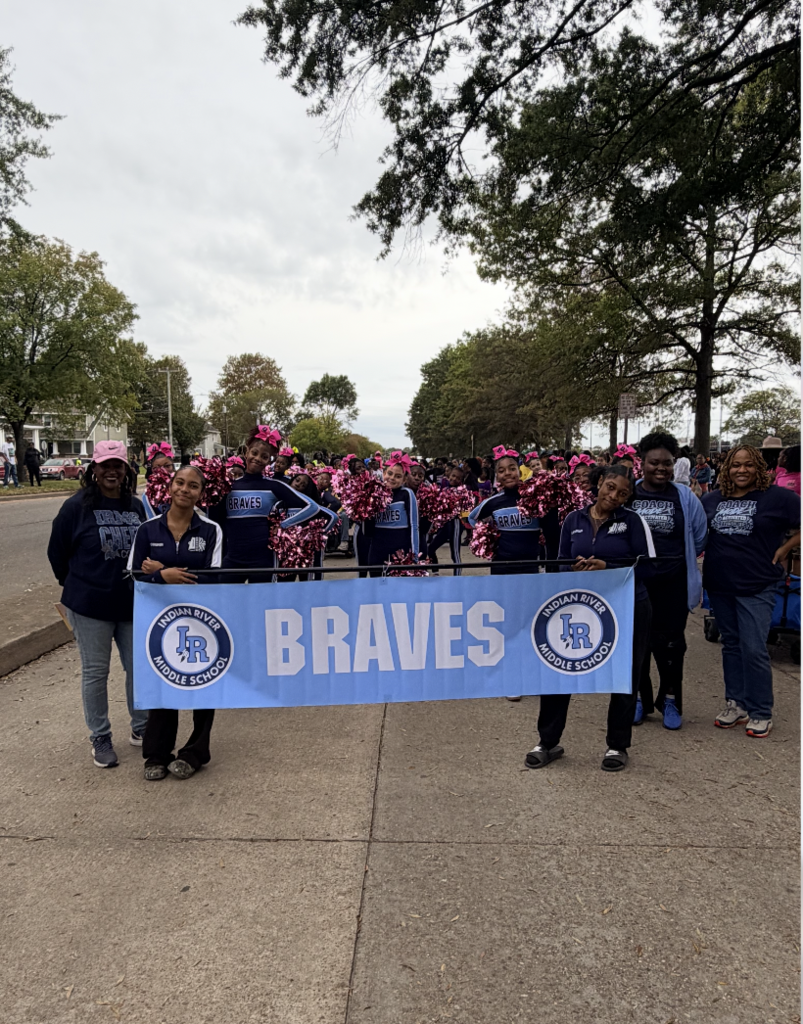 IRM Braves Cheerleaders at the NSU parade holding a banner that says Braves 