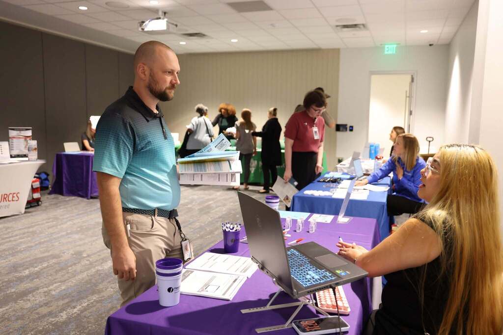 Employee speaking with a benefits provider at the Open Enrollment Fair.