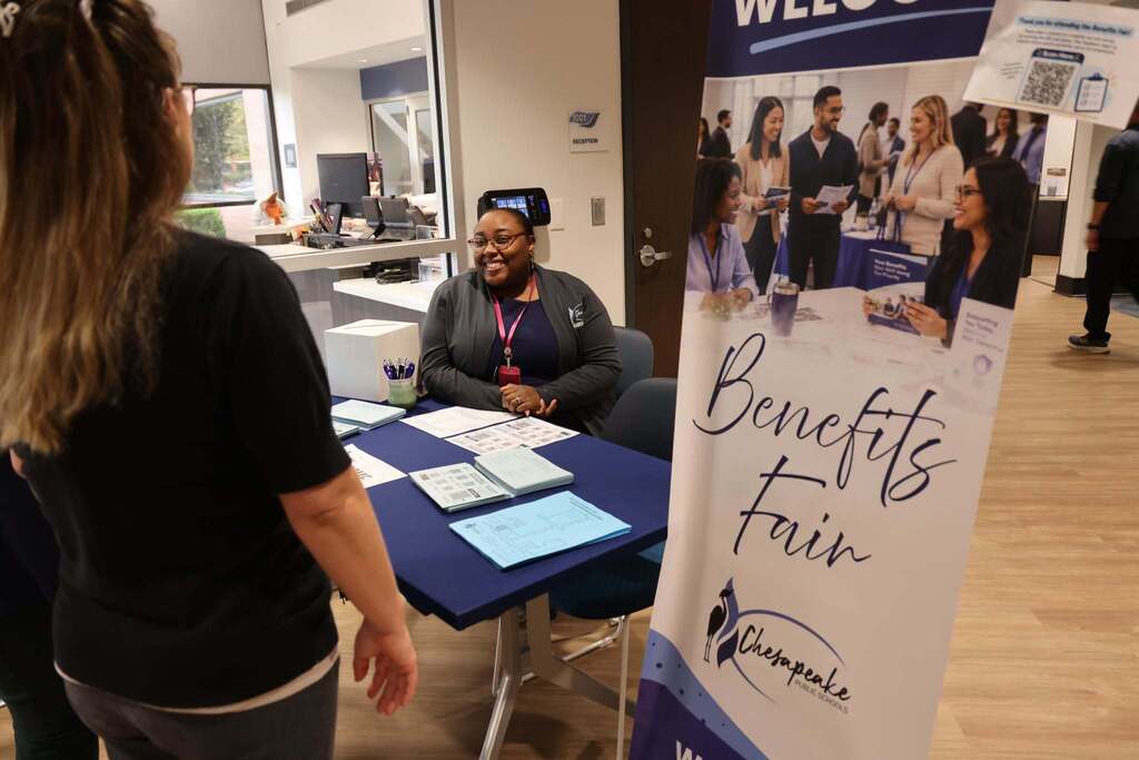 An employee welcoming people to the fair.