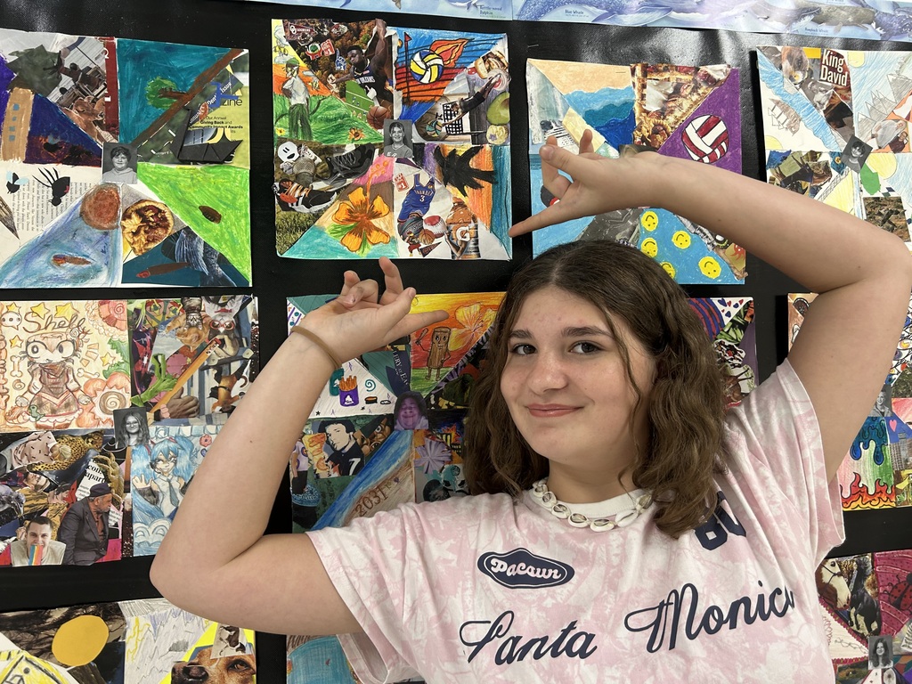 student proudly posing with her artwork