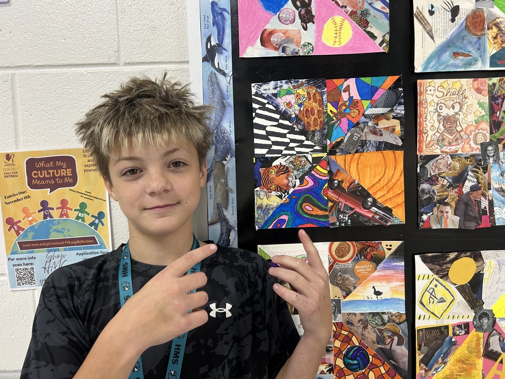 student proudly posing with his artwork