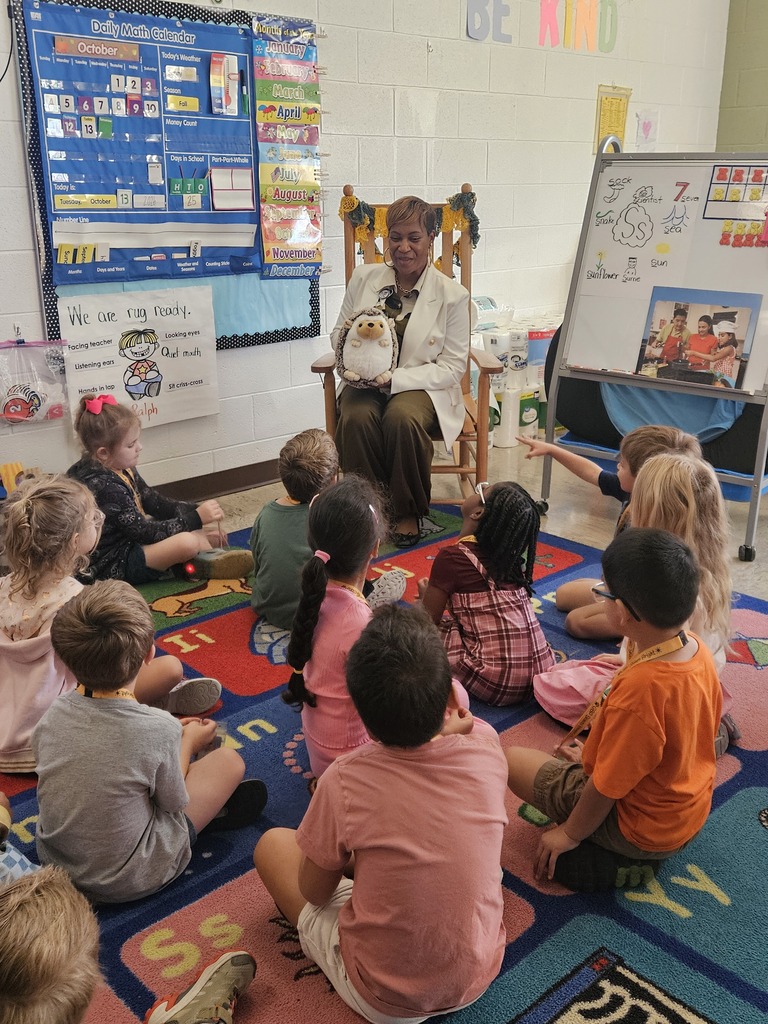 Ms. Baker-Hardison holding Hedgie the Hedgehog stuffed animal as she reads aloud to Mrs. Kiskinis' class.