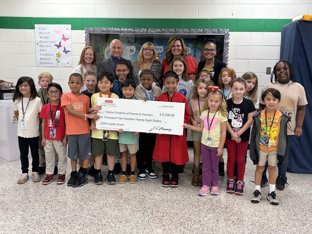 A group of elementary school students and adults stand together in a hallway posing with a large ceremonial check presented by JCPenney Communities Foundation. The check is made out to the Virginia Congress of Parents & Teachers in the amount of $6,228.00 for a 2026 Leader Grant.
