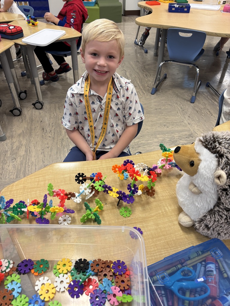 Mrs. Tummons' student posing with the stuffed animal Hedgie the Hedgehog