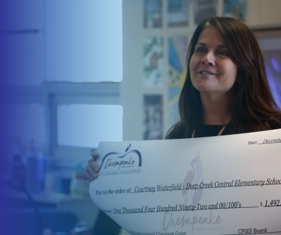 Teacher smiling holding a large check