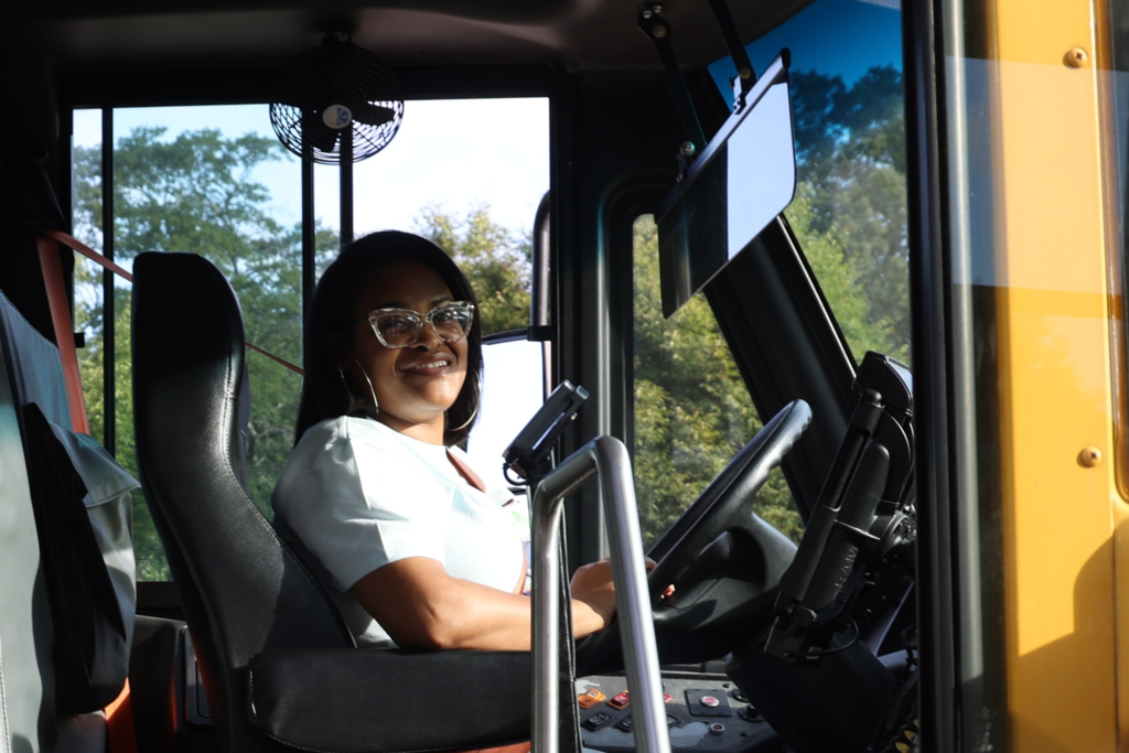 bus driver smiles from bus on first day