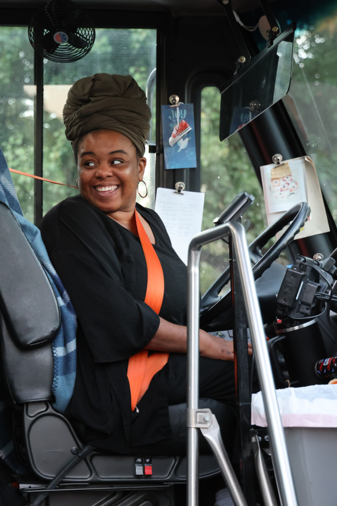 bus driver smiles from bus on first day