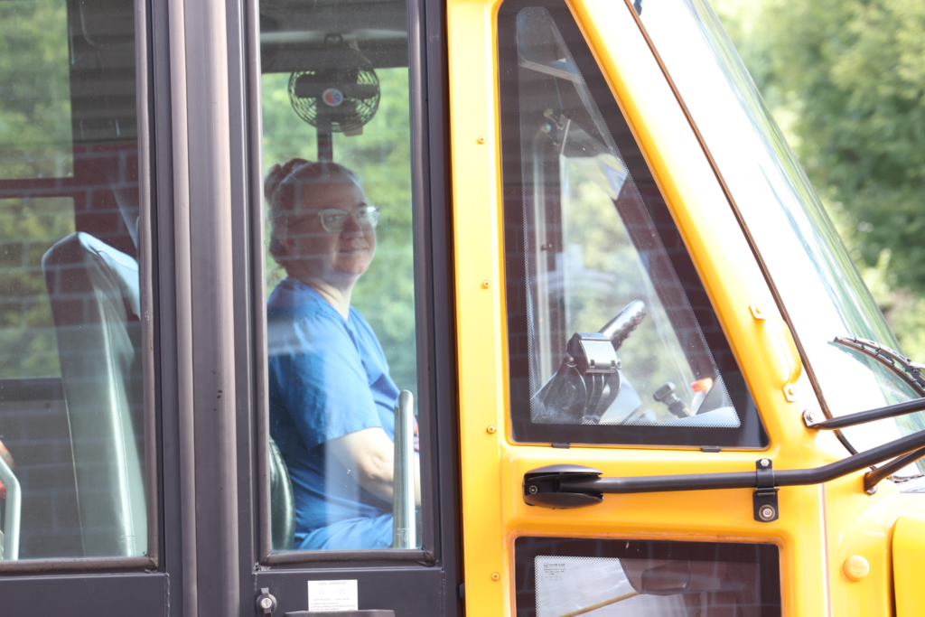 bus driver smiles from bus on first day