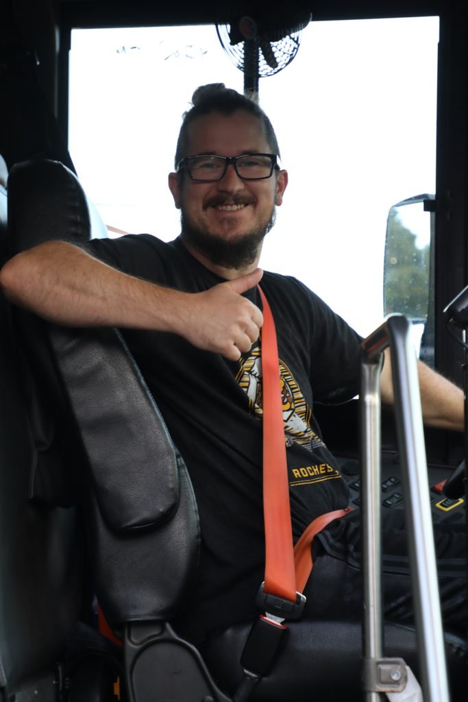 bus driver smiles from bus on first day