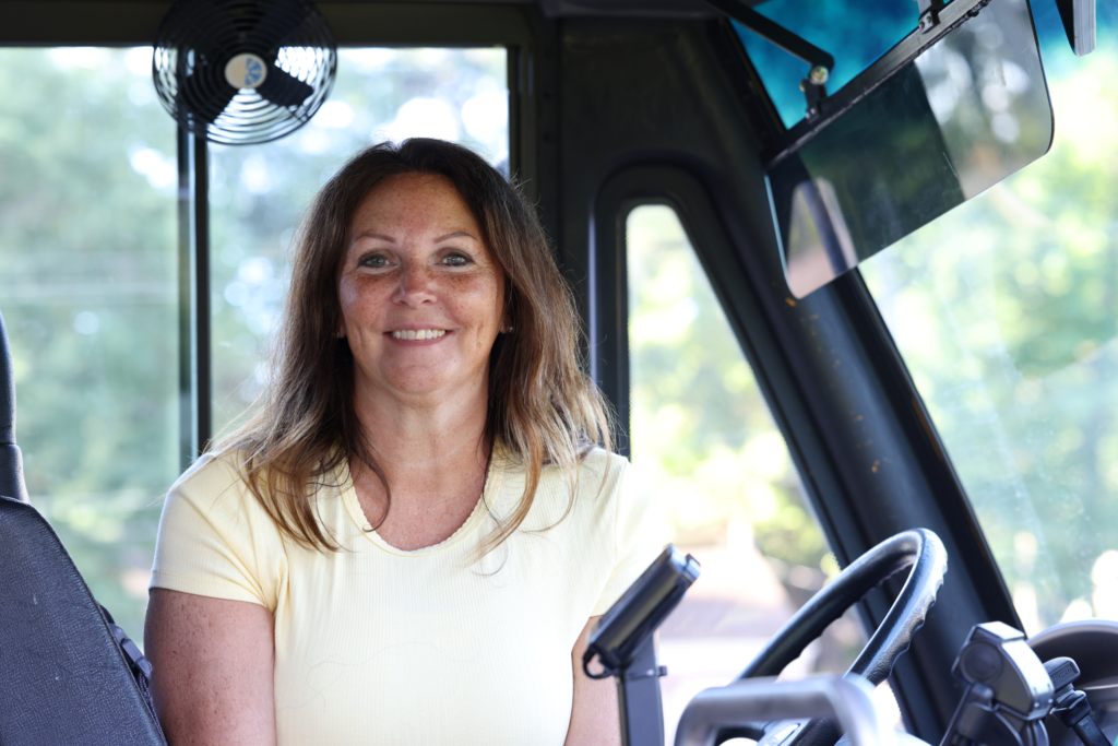 bus driver smiles from bus on first day