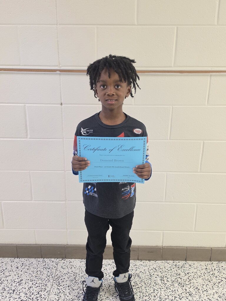 IXL Leaderboad third place winner for first grade poses with certificate