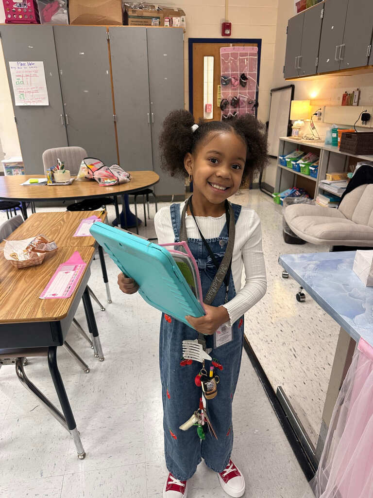 student dressed as teacher for career day, wearing a lanyard and holding a clipboard