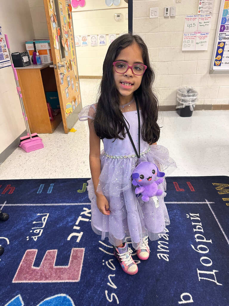 student dressed in purple dress with purple fluffy purse, dressed as a Hollywood actress for career day