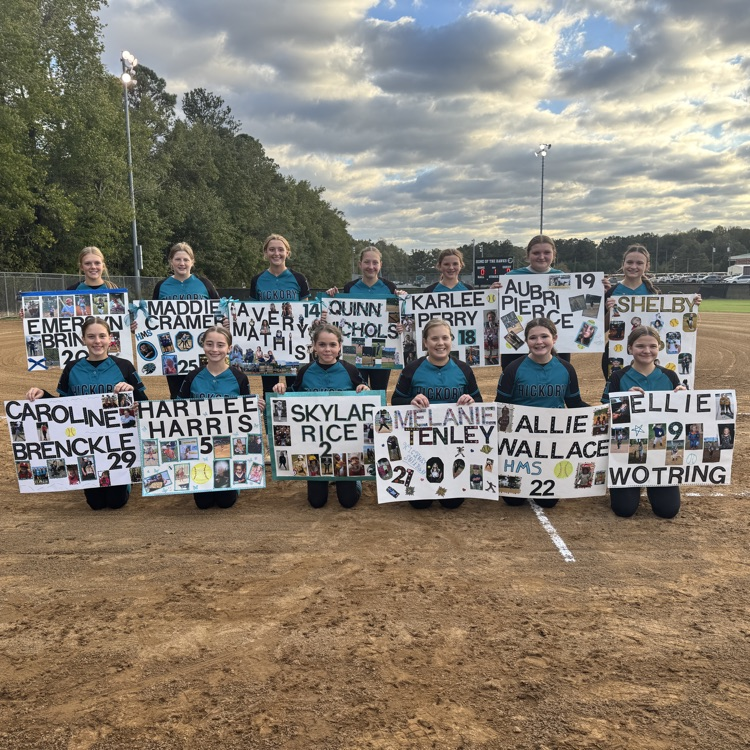 8th grade players smiling while holding their posters