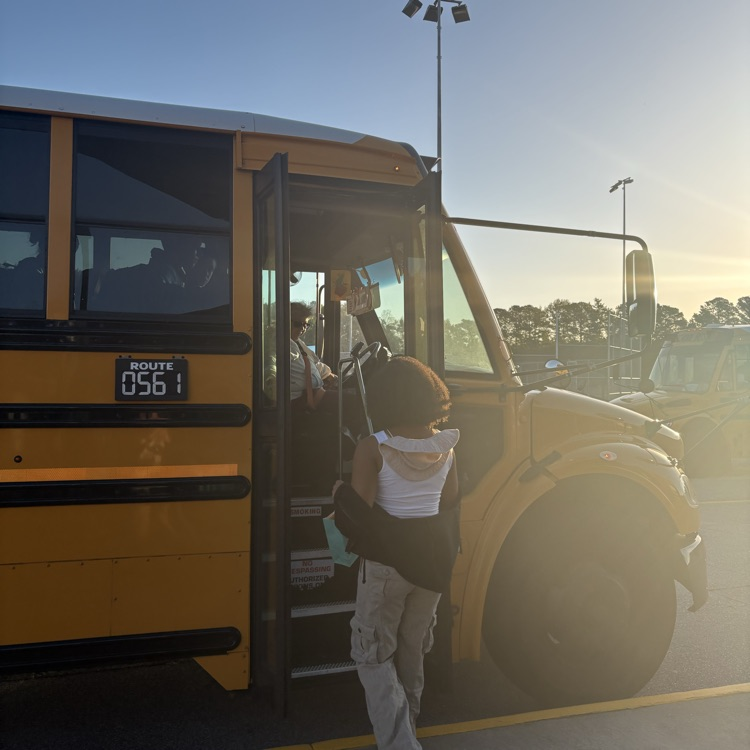 student delivering bag to bus driver