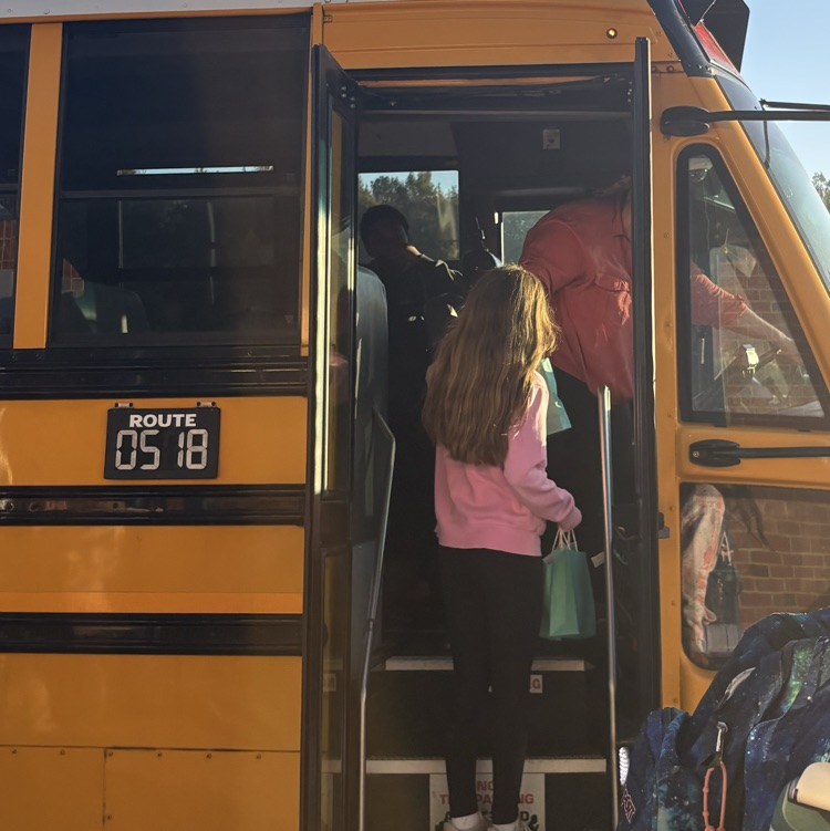 student delivering bag to bus driver