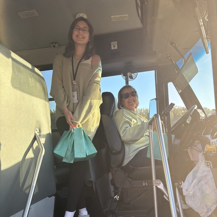 student delivering bag to bus driver
