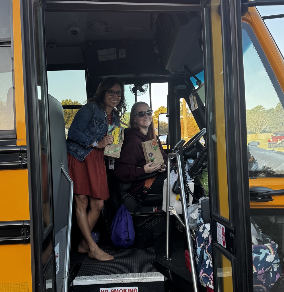 BRI students smiling with their school bus drivers in appreciation of School Bus Safety & Appreciation Week.
