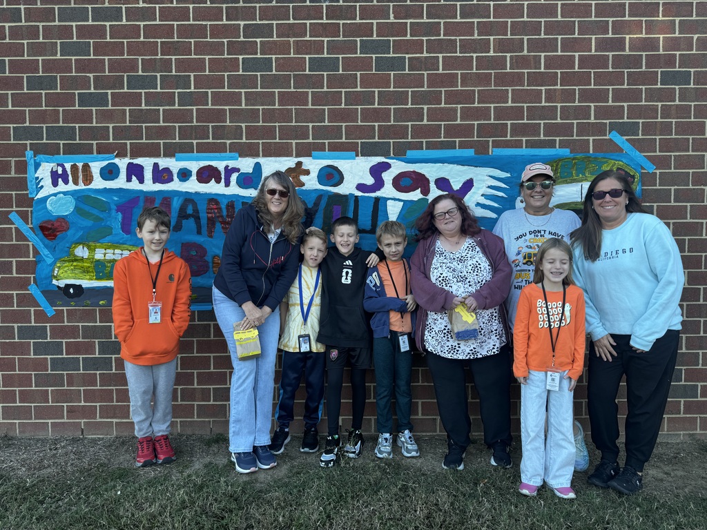 BRI students smiling with their school bus drivers in appreciation of School Bus Safety & Appreciation Week.