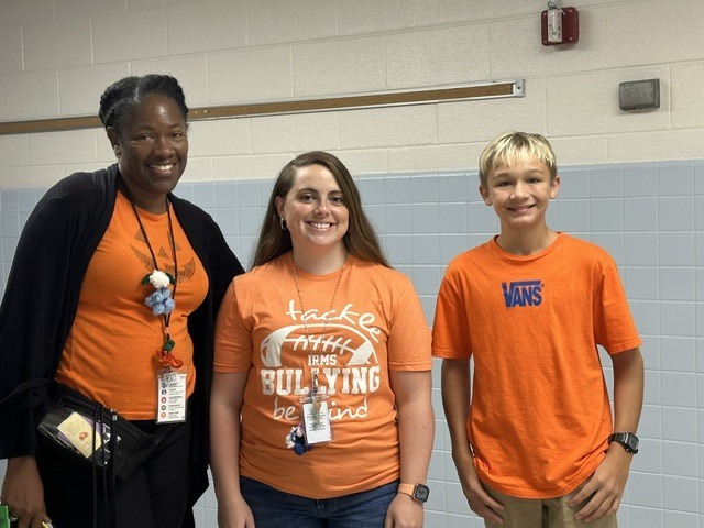 teachers standing with a student on unity day