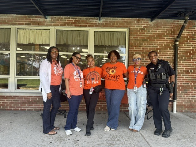 staff members standing together, wearing orange for unity day