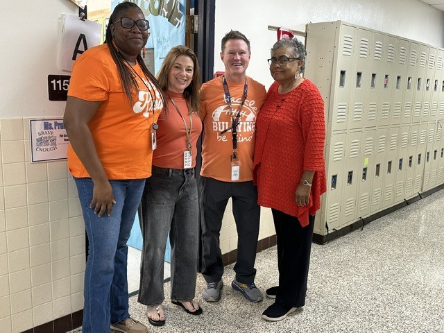 teachers standing together, wearing orange for unity day