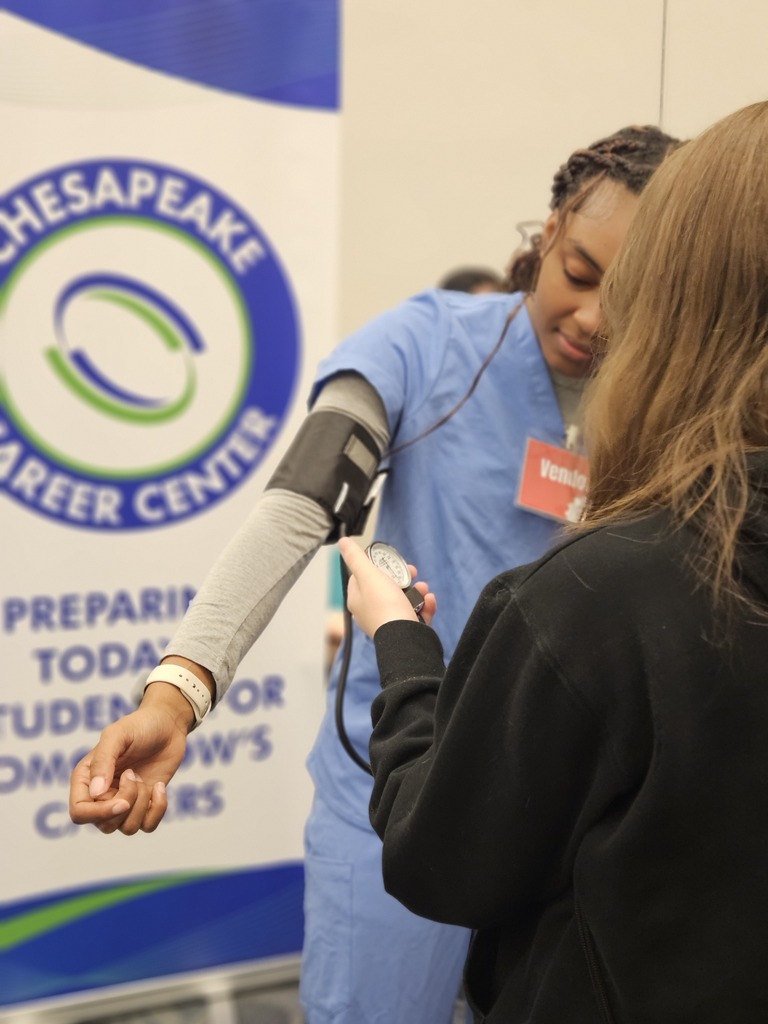 Patient Care Tech students at world of works showing their program to 8th graders.
